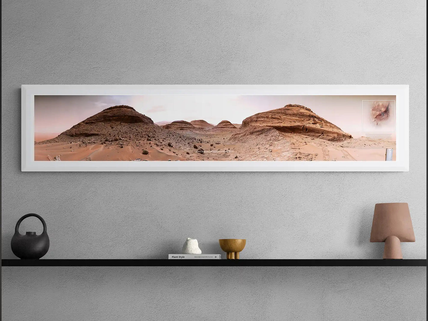 Framed panoramic Mars landscape poster from the Curiosity Rover, displayed on a black shelf with modern minimalist decor, including a lamp, ceramics, and a book.
