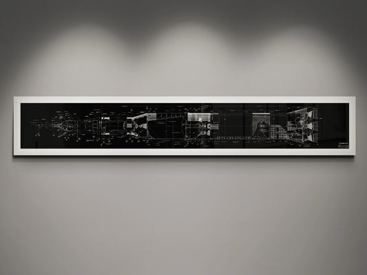 Apollo Saturn V | Rocket Blueprint Posters | NASA | A framed blueprint of the NASA Saturn V rocket, displaying detailed technical drawings in white on a black background. The blueprint is mounted on a gray wall and illuminated by subtle lighting from above.