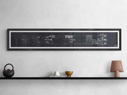 Apollo Saturn V | Rocket Blueprint Posters | Technical Diagram | NASA | A minimalist interior with a black shelf displaying decorative items, including a small sculpture, a gold bowl, and a brown lamp. Above the shelf, a white-framed blueprint of the NASA Saturn V rocket with technical schematics in white on a black background is mounted on a light gray wall.