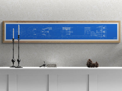 Apollo Saturn V | Rocket Blueprint Posters | Technical Diagram | NASA | A decorative setup with a white shelf holding black candlesticks, a bird figurine, a patterned box, and pinecones. A light wood-framed blueprint of the NASA Saturn V rocket, featuring intricate technical drawings in blue and white, hangs on the patterned white wall above.