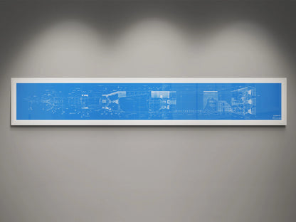 Apollo Saturn V | Rocket Blueprint Posters | NASA | A detailed blueprint of the NASA Saturn V rocket displayed in a white frame against a gray wall. The blueprint is in blue with white technical schematics, illuminated by subtle overhead lighting.